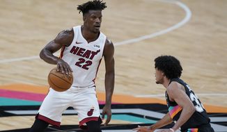 Miami Heat forward Jimmy Butler (22) drives around San Antonio Spurs guard Tre Jones (33) during the second half of an NBA basketball game in San Antonio, Wednesday, April 21, 2021. (AP Photo/Eric Gay)