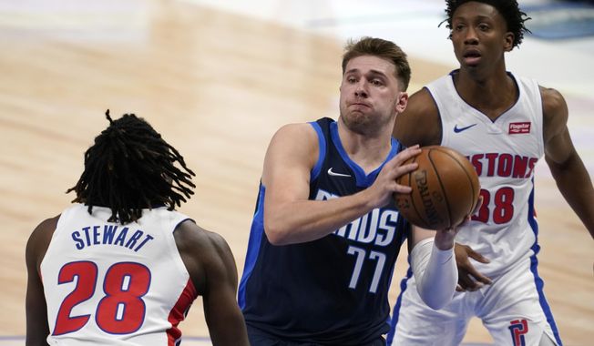 Detroit Pistons&#x27; Isaiah Stewart (28) and Saben Lee, rear, defend as Dallas Mavericks guard Luka Doncic (77) drives to the basket during the first half of an NBA basketball game in Dallas, Wednesday, April 21, 2021. (AP Photo/Tony Gutierrez)