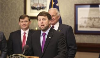 Peter McCoy speaks at a news conference after South Carolina Gov. Henry McMaster, rear right, announced he wants to appoint him chairman of state-owned utility Santee Cooper, Wednesday, April 21, 2021, in Columbia, S.C. McCoy is a former South Carolina House member and U.S. Attorney in the state. (AP Photo/Jeffrey Collins)