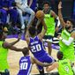 The Minnesota Timberwolves center Karl-Anthony Towns (32) defends the basket as Sacramento Kings center Hassan Whiteside (20) shoots during the first quarter of an NBA basketball game in Sacramento, Calif., Tuesday, April 20, 2021. (AP Photo/Randall Benton)