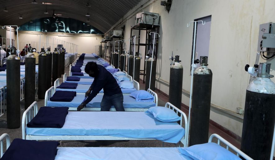 A worker cleans a newly set up C0VID- 19 hospital at Science Center in Mumbai, India, Tuesday April 13, 2021. India has been overwhelmed by hundreds of thousands of new coronavirus cases daily, bringing pain, fear and agony to many lives as lockdowns have been placed in Delhi and other cities around the country. (AP Photo/Rajanish Kakade)