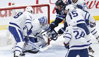 Winnipeg Jets&#39; Pierre-Luc Dubois (13) and Paul Stastny (25) scramble for the puck in front of Toronto Maple Leafs goaltender Jack Campbell (36) as TJ Brodie (78) and Alexander Kerfoot (15) defend during the first period of an NHL hockey game Thursday, April 22, 2021, in Winnipeg, Manitoba. (John Woods/The Canadian Press via AP)