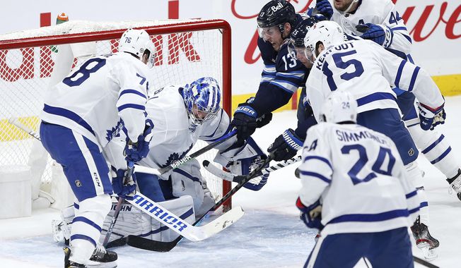 Winnipeg Jets&#x27; Pierre-Luc Dubois (13) and Paul Stastny (25) scramble for the puck in front of Toronto Maple Leafs goaltender Jack Campbell (36) as TJ Brodie (78) and Alexander Kerfoot (15) defend during the first period of an NHL hockey game Thursday, April 22, 2021, in Winnipeg, Manitoba. (John Woods/The Canadian Press via AP)