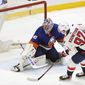 Washington Capitals center Evgeny Kuznetsov (92) and New York Islanders goaltender Semyon Varlamov (40) look into the net after Kuznesov scored in the  shootout of an NHL hockey game,Thursday, April 22, 2021, in Uniondale, N.Y. The Capitals won 1-0. (AP Photo/Kathy Willens)
