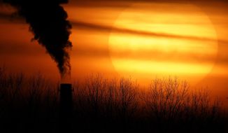 In this Feb. 1, 2021 file photo, emissions from a coal-fired power plant are silhouetted against the setting sun in Independence, Mo. (AP Photo/Charlie Riedel, File)