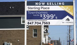 An advertising sign for building land stands in front of a new home construction site in Northbrook, Ill., Sunday, March 21, 2021.  Mortgage rates fell for a second straight week amid signs of economic improvement. Mortgage buyer Freddie Mac reports, Thursday, April 15,  that the benchmark 30-year home-loan rate declined to 3.04% this week from 3.13% last week.  (AP Photo/Nam Y. Huh)