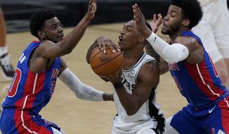 San Antonio Spurs guard Lonnie Walker IV, center, is pressured by Detroit Pistons guard Josh Jackson, left, and forward Saddiq Bey, right, during the second half of an NBA basketball game in San Antonio, Thursday, April 22, 2021. (AP Photo/Eric Gay)