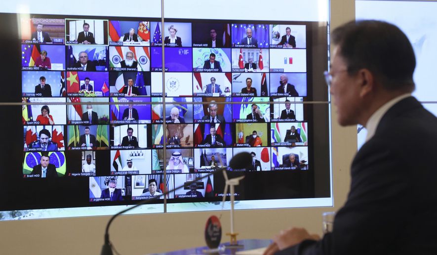South Korean President Moon Jae-in, right, speaks as the screen showing world leaders at the virtual Leaders Summit on Climate, at the presidential Blue House in Seoul, South Korea, Thursday, April 22, 2021. (Lee Jin-wook/Yonhap via AP)