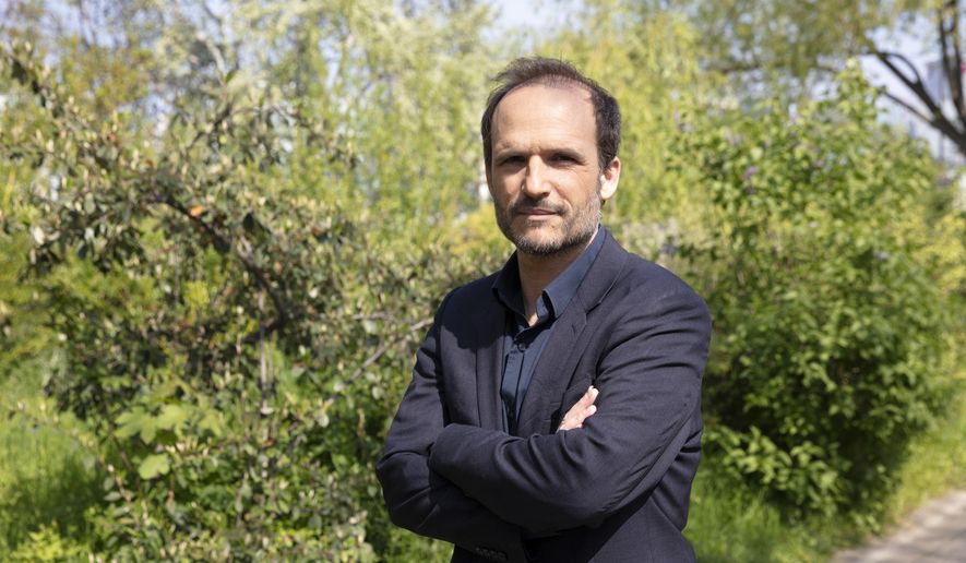 Thomas Lilti, the director of hit French medical drama "Hippocrate," a former doctor himself, poses in Paris, France, Thursday, April 22, 2021. Lilti was so moved by the urgency of the pandemic that he couldn't just stand back, he put back on his scrubs. Lilti ended up back working in hospital when filming of his second season was suspended by the lockdown last year, eight weeks in, truth sometimes stranger than fiction. (AP Photo/Oleg Cetinic)