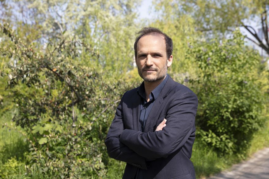 Thomas Lilti, the director of hit French medical drama "Hippocrate," a former doctor himself, poses in Paris, France, Thursday, April 22, 2021. Lilti was so moved by the urgency of the pandemic that he couldn't just stand back, he put back on his scrubs. Lilti ended up back working in hospital when filming of his second season was suspended by the lockdown last year, eight weeks in, truth sometimes stranger than fiction. (AP Photo/Oleg Cetinic)