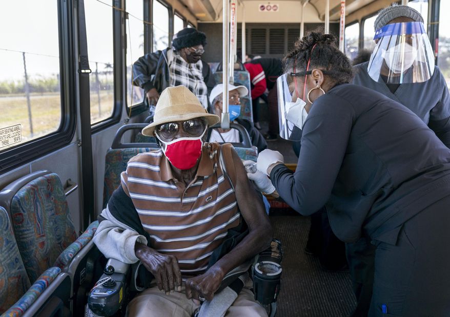 In this Feb. 3, 2021, file photo, a senior receives a COVID-19 vaccine from a health care worker after arriving on a bus to a vaccination site at Anquan Boldin Stadium in Pahokee, Fla. COVID-19 hospitalizations are plunging among older Americans. The falling numbers show the country’s vaccination strategy is working, pushing death rates lower and easing pressure on the frayed hospital system. (Greg Lovett/The Palm Beach Post via AP, File)