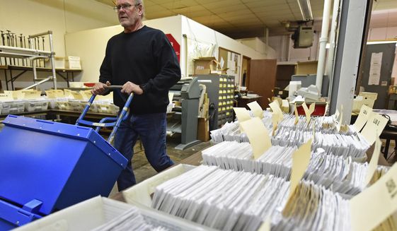 This Tuesday, Nov. 3, 2020 file photo shows Board of Elections worker Bob Moody moving boxes of ballots at the Trumbull County Board of Elections in Warren, Ohio. (AP Photo/David Dermer, File)