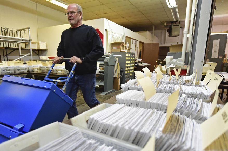 This Tuesday, Nov. 3, 2020 file photo shows Board of Elections worker Bob Moody moving boxes of ballots at the Trumbull County Board of Elections in Warren, Ohio. (AP Photo/David Dermer, File)