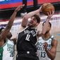 Brooklyn Nets forward Joe Harris (12) goes to the basket against Boston Celtics forward Aaron Nesmith (26) and center Tristan Thompson (13) during the second half of an NBA basketball game Friday, April 23, 2021, in New York. (AP Photo/Mary Altaffer)