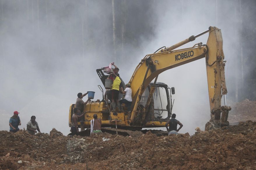 Gold miners on a bulldozer try to put out a fire set by the National Police at an illegal mining operation as part of the Armed Forces&#x27; &amp;quot;Operation Guamuez III&amp;quot; in Magui Payan, Colombia, Tuesday, April 20, 2021. None of the workers were detained during the destruction of machinery, but in previous days some machinists and material suppliers were detained, according to Army Col. Pedro Pablo Astaiza. (AP Photo/Fernando Vergara)