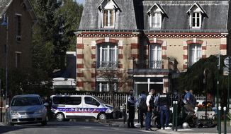 Police officers gather next to the Police station in Rambouillet, south west of Paris, Friday, April 23, 2021. A French police officer was stabbed to death inside her police station Friday near the famed historic Rambouillet chateau, and her attacker was shot and killed by officers at the scene, authorities said. The identity and the motive of the assailant were not immediately clear, a national police spokesperson told The Associated Press. The police officer was a 49-year-old administrative employee in the station, the spokesperson said. (AP Photo/Michel Euler)