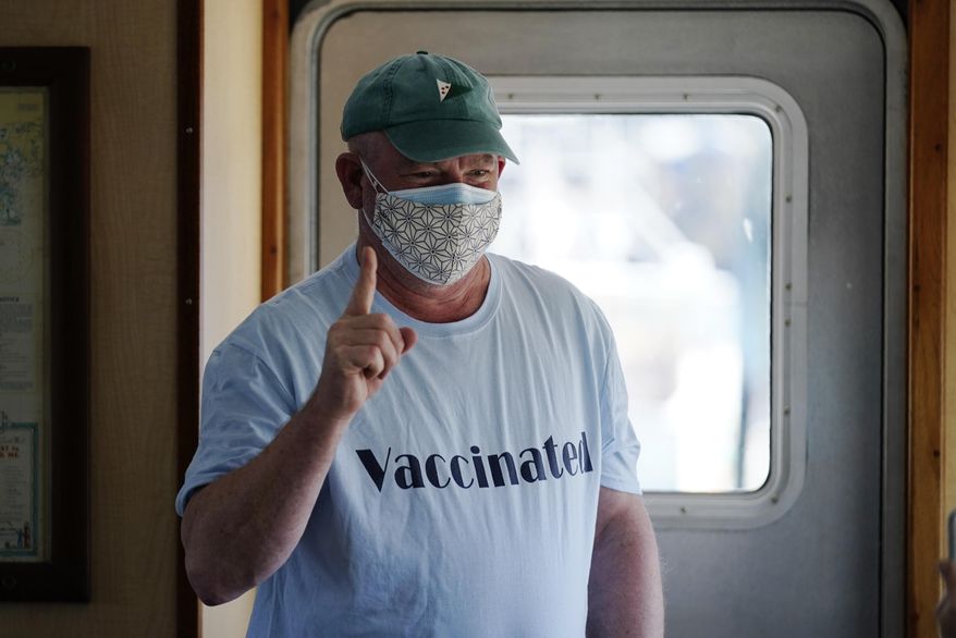 FILE-In this Friday, March 19, 2021, file photo, Jonathan Partin wears an appropriate tee-shirt as he celebrates receiving a COVID-19 vaccination aboard the Sunbeam in Northeast Harbor, Maine. The Sunbeam is a 74-foot vessel operated by the non-profit Maine Seacoast Mission. The mission has vaccinated hundreds of people who reside on Maine islands. (AP Photo/Robert F. Bukaty, file)