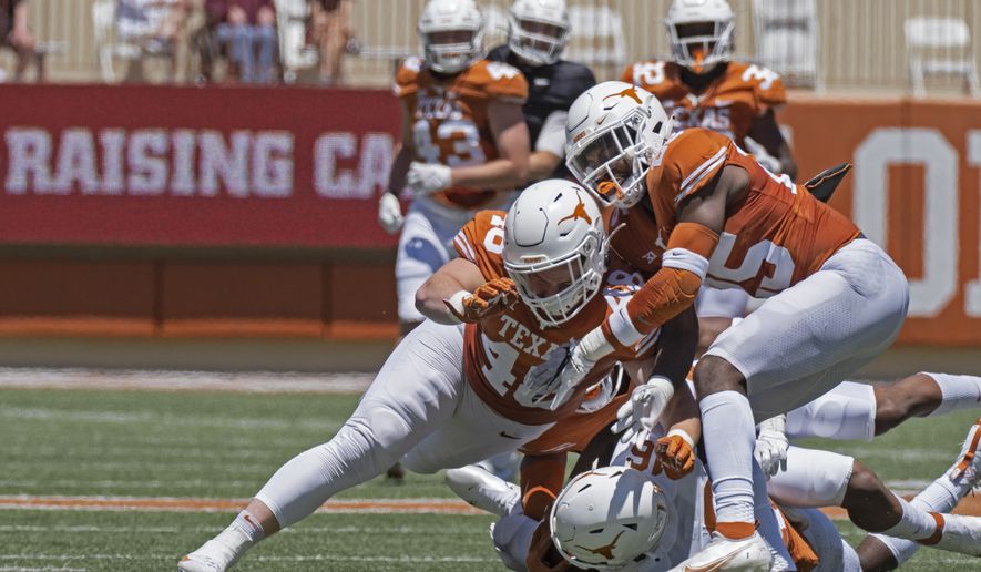 Texas defenders Jake Ehlinger, left, and B.J. Foster, right, tackle Kayvontay Dixon (16) during the first half of the Texas Orange and White Spring Scrimmage football game in Austin, Texas, Saturday, April 24, 2021. (AP Photo/Michael Thomas) **FILE**