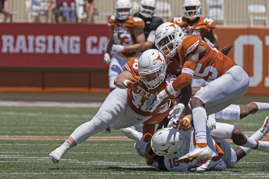 Texas defenders Jake Ehlinger, left, and B.J. Foster, right, tackle Kayvontay Dixon (16) during the first half of the Texas Orange and White Spring Scrimmage football game in Austin, Texas, Saturday, April 24, 2021. (AP Photo/Michael Thomas) **FILE**
