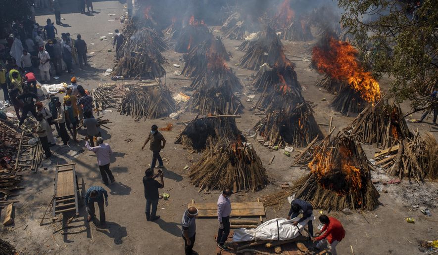 Multiple funeral pyres of victims of COVID-19 burn at a ground that has been converted into a crematorium for mass cremation in New Delhi, India, Saturday, April 24, 2021. Indian authorities are scrambling to get medical oxygen to hospitals where COVID-19 patients are suffocating from low supplies. The effort Saturday comes as the country with the world’s worst coronavirus surge set a new global daily record of infections for the third straight day. The 346,786 infections over the past day brought India’s total past 16 million. (AP Photo/Altaf Qadri)