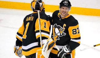 Pittsburgh Penguins&#39; Sidney Crosby (87) celebrates with goaltender Casey DeSmith after a 4-2 win over the New Jersey Devils in an NHL hockey game in Pittsburgh, Saturday, April 24, 2021. (AP Photo/Gene J. Puskar)