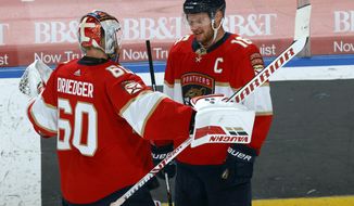 Florida Panthers goaltender Chris Driedger (60) celebrates with center Aleksander Barkov (16), who scored in overtime of the team&#39;s NHL hockey game against the Carolina Hurricanes, Saturday, April 24, 2021, in Sunrise, Fla. (AP Photo/Joel Auerbach)
