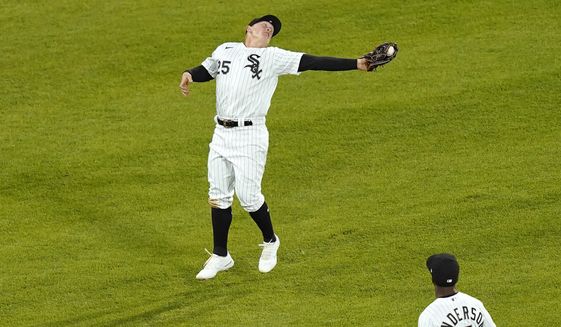 Chicago White Sox&#39;s Andrew Vaughn makes an awkward catch of a fly ball hit by Texas Rangers&#39; Nate Lowe during the fifth inning of a baseball game Friday, April 23, 2021, in Chicago. (AP Photo/Charles Rex Arbogast)