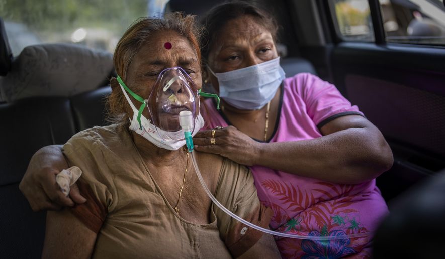 A COVID-19 patient receives oxygen inside a car provided by a Gurdwara, a Sikh house of worship, in New Delhi, India, Saturday, April 24, 2021. India’s medical oxygen shortage has become so dire that this gurdwara began offering free breathing sessions with shared tanks to COVID-19 patients waiting for a hospital bed. They arrive in their cars, on foot or in three-wheeled taxis, desperate for a mask and tube attached to the precious oxygen tanks outside the gurdwara in a neighborhood outside New Delhi. (AP Photo/Altaf Qadri)