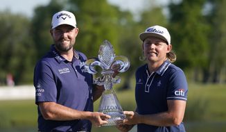 Marc Leishman, of Australia, left, and teammate Cameron Smith, of Australia, hold the trophy after winning the PGA Zurich Classic golf tournament at TPC Louisiana in Avondale, La., Sunday, April 25, 2021. (AP Photo/Gerald Herbert)