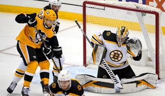 Boston Bruins goaltender Jeremy Swayman (1) gloves a shot with Kevan Miller (86) defending Pittsburgh Penguins&#39; Teddy Blueger (53) during the first period of an NHL hockey game in Pittsburgh, Sunday, April 25, 2021.(AP Photo/Gene J. Puskar)