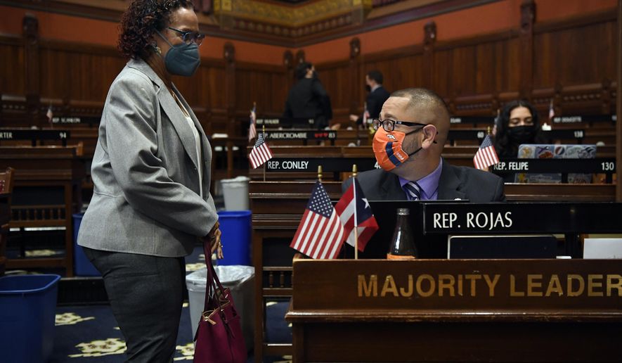 Connecticut House Majority Leader Jason Rojas, D-East Hartford, right, speaks with State Rep. Toni Walker, D-New Haven, left, during session at the State Capitol in Hartford, Conn., on Monday, April 19, 2021. In July 2020 after George Floyd was killed in Minneapolis, Black and Latino members of the Connecticut General Assembly worked to enact sweeping changes to policing in the state, and since, have continue to flex their collective muscles. (AP Photo/Jessica Hill)