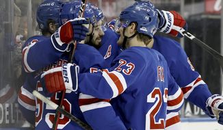 New York Rangers&#x27; Mika Zibanejad (93) is surrounded by teammates after he scored a hat trick in the second period against the Buffalo Sabres during an NHL hockey game Sunday, April 25, 2021, in New York. (Elsa/Pool Photo via AP)