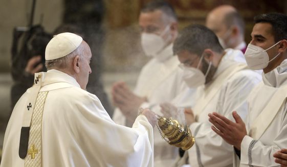 Pope Francis spreads incense during a ceremony to ordain nine new priests, standing in front of him and wearing face masks to curb the spread of COVID-19, inside St. Peter&#39;s Basilica, at the Vatican, Sunday, April 25, 2021. (AP Photo/Andrew Medichini)