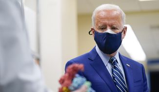 In this Feb. 11, 2021, photo President Joe Biden looks at a model of COVID-19 as he visits the Viral Pathogenesis Laboratory at the National Institutes of Health in Bethesda, Md. (AP Photo/Evan Vucci) **FILE**