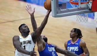 New Orleans Pelicans forward Zion Williamson (1) goes to the basket against LA Clippers center DeMarcus Cousins (15) in the second half of an NBA basketball game in New Orleans, Monday, April 26, 2021. The Pelicans won 120-103. (AP Photo/Gerald Herbert)