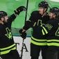 Dallas Stars forward Denis Gurianov, center, is congratulated by forward Jason Dickinson (18) and defenseman Roman Polak (45) after scoring a goal during the second period of an NHL hockey game against the Carolina Hurricanes, Monday, April 26, 2021, in Dallas. (AP Photo/Brandon Wade)