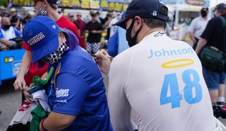 IndyCar driver  Jimmie Johnson (48) signs the shirt of fan Caroline Gast of Sarasota after the morning practice session at the Grand Prix of St. Petersburg auto race, Sunday, April 25, 2021 in St. Petersburg, Fla. (Luis Santana/Tampa Bay Times via AP)