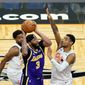 Los Angeles Lakers forward Anthony Davis (3) takes shot as he gets between Orlando Magic guard Chasson Randle, left, and forward Chuma Okeke (3)during the first half of an NBA basketball game, Monday, April 26, 2021, in Orlando, Fla. (AP Photo/John Raoux)