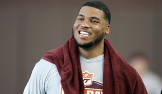 FILE - Christian Darrisaw smiles after completing a set of offensive line drills during Virginia Tech Pro Day in Blacksburg, Va., in this Friday, March 26, 2021, file photo. Darrisaw is a possible first round pick in the NFL Draft, April 29-May 1, 2021, in Cleveland. (AP Photo/Matt Gentry, File)