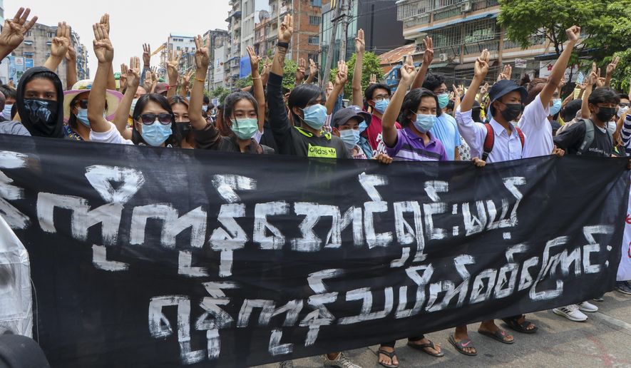 Anti-coup protesters flash the three-finger salute, holding banner read &amp;quot; Yangon Strike will defeat all enemies&amp;quot; during a demonstration against the military coup in Yangon, Myanmar, on Monday, April 26, 2021. Southeast Asian leaders have demanded an immediate end to killings and the release of political detainees in Myanmar during an emergency summit in Jakarta with its top general and coup leader. (AP Photo)