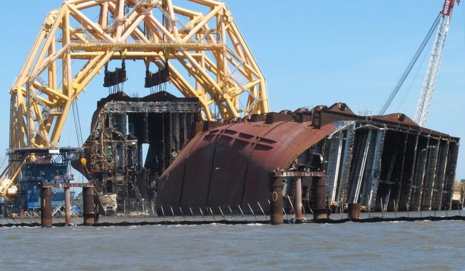 A towering crane pulls the engine room section away from the remains of the capsized cargo ship Golden Ray on Monday, April 26, 2021, offshore of St. Simons Island, Ga. The South Korean vessel capsized with roughly 4,200 vehicles in its cargo decks in September 2019. The engine room section is the fourth giant chunk of the ship to be cut away and removed since demolition began in November 2020. (AP Photo/Russ Bynum)