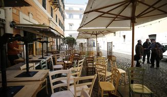 Chairs and tables are being prepared outside a restaurant ahead of Monday&#39;s reopening following the ease of COVID-19 restrictions, in Rome, Friday, April 23, 2021. Even Italy’s tentative reopening is satisfying no one. Outdoor dining is too little, too late for restaurant owners whose survival is threatened by a year of rotating closures. Yet the nation’s weary virologists worry that Monday, April 26, 2021, will see people crowding bars and restaurants and bring yet another spike to the virus that has not really properly receded yet. (Cecilia Fabiano/LaPresse via AP)