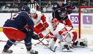 Detroit Red Wings&#39; Thomas Greiss, front right, makes a save as teammate Joe Valeno, left center, and Columbus Blue Jackets&#39; Alexandre Texier, left, and Cam Atkinson look for the rebound during the second period of an NHL hockey game Tuesday, April 27, 2021, in Columbus, Ohio. (AP Photo/Jay LaPrete)