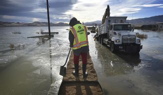 FILE - In this Dec. 19, 2017, file photo, Washoe County sets up some HESCO barriers on the edge of Swan Lake floodwaters in Lemmon Valley, north of Reno, Nev. Reno city officials say they&#39;ve reached a tentative agreement to pay $4.5 million to settle a lawsuit brought by residents whose Lemmon Valley homes were flooded north of town in 2017 after the city diverted excess storm water into a local lake basin. The city council is expected to approve the payment on May 12, 2021, which would resolve all existing state and federal lawsuits, the Reno Gazette Journal reported. (Jason Bean/The Reno Gazette-Journal via AP, File)