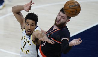 Indiana Pacers guard Malcolm Brogdon, left, and Portland Trail Blazers center Jusuf Nurkic reach for a rebound during the first half of an NBA basketball game in Indianapolis, Tuesday, April 27, 2021. (AP Photo/AJ Mast)