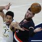 Indiana Pacers guard Malcolm Brogdon, left, and Portland Trail Blazers center Jusuf Nurkic reach for a rebound during the first half of an NBA basketball game in Indianapolis, Tuesday, April 27, 2021. (AP Photo/AJ Mast)
