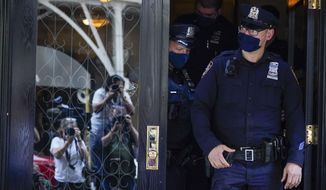 Members of the media are reflected in the widow a door as New York City Police officers walk out of the apartment building where former New York Mayor Rudy Giuliani resides, Wednesday, April 28, 2021, in New York. Federal agents on Wednesday raided Giulianis Manhattan home and office, seizing computers and cell phones in a major escalation of the Justice Departments investigation into the business dealings of former President Donald Trumps personal lawyer. (AP Photo/Mary Altaffer)