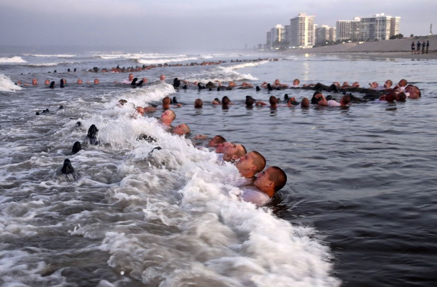 This May 4, 2020, photo provided by the U.S. Navy shows SEAL candidates participating in "surf immersion" during Basic Underwater Demolition/SEAL (BUD/S) training at the Naval Special Warfare (NSW) Center in Coronado, Calif. U.S. Navy SEALs are undergoing a major transition to improve leadership and expand their commando capabilities. (MC1 Anthony Walker/U.S. Navy via AP)