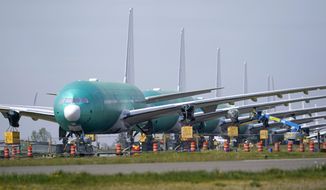 A line of Boeing 777X jets are parked nose to tail on an unused runway at Paine Field, near Boeing&#39;s massive production facility, Friday, April 23, 2021, in Everett, Wash.  Boeing Co. on Wednesday, April 28,  reported a loss of $537 million in its first quarter. The Chicago-based company said it had a loss of 92 cents per share. Losses, adjusted for non-recurring gains, were $1.53 per share.  (AP Photo/Elaine Thompson)