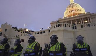 In this Wednesday, Jan. 6, 2021, file photo, police form a line to guard the U.S. Capitol after violent rioters stormed the building, in Washington. (AP Photo/John Minchillo)